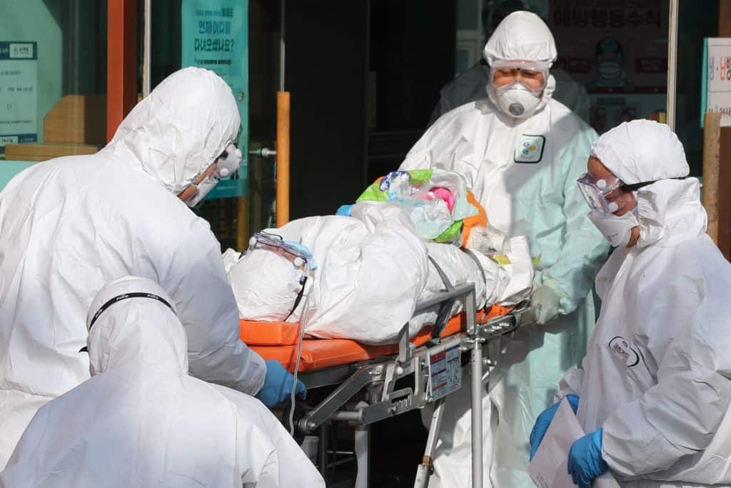 A coronavirus victim being hospitalized on Feb. 21, 2020 in Daegu, South  Korea. Countries, businesses, families, and individuals should hold China liable for worldwide coronavirus costs, injuries, and deaths. 