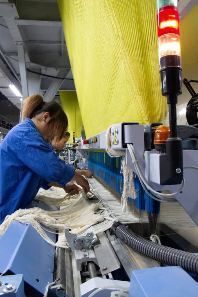 Textile workers in Xinjiang, China, where Beijing's Communist regime is compelling up to a million Uighur Muslims to undergo "re-education" while forced to work in prison factories. The use of forced labor automatically exempts a traded good from any protection under international trade law.