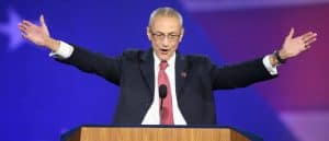 Former Hillary Clinton campaign manager John Podesta, arms extended in "I'm here to save the world" gesture